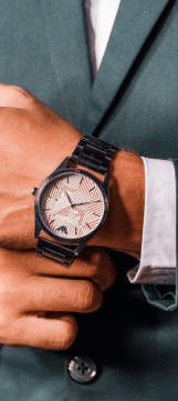 A close-up of a man's hand wearing a black mechanic watch, showcasing its detailes sesign and craftsmanship