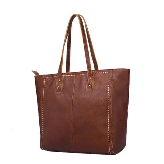 Handmade brown leather Toto bag for women, featuring a sleek and stylish design with a smooth, rich texture. The bag has sturdy handles, a spacious interior, and a minimalist yet elegant appearance, making it perfect for everyday use or special occasions.