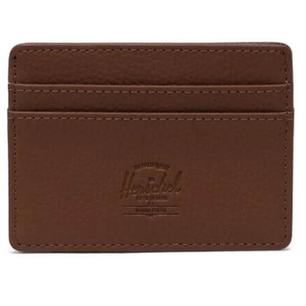 Brown Herschel Charlie Leather Wallet with a sleek and compact design, featuring a textured leather exterior and the Herschel logo embossed on the front. The wallet includes a main compartment for cards and cash, with a slim profile for easy storage in pockets or bags.